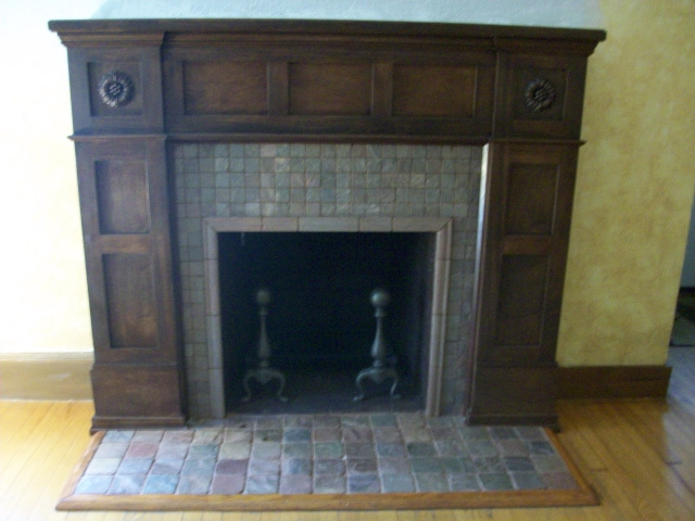 A Custom Arts & Crafts Mantel in hand rubbed English Chestnut with Arts & Crafts Stone Tile Surround and Hearth are complimented by the restored Andirons.
