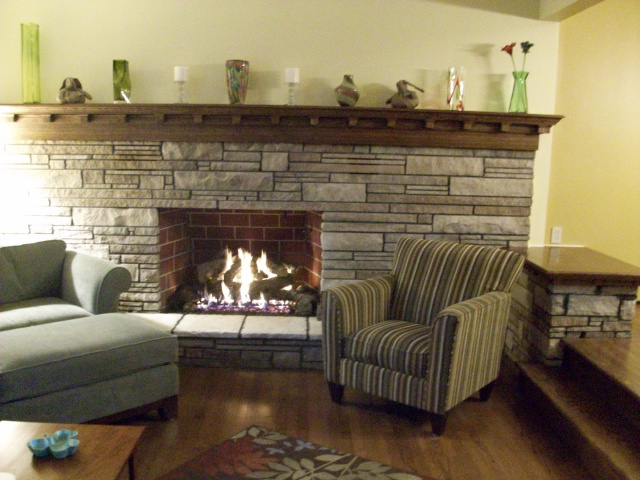 A 15 Foot Custom Arts & Crafts Mantel in hand rubbed English Chestnut with Matching Table Top, Stone Cleaning, Firebox Firebrick Panels, Variable Flame Gas Log Set and New Hearth Stones.