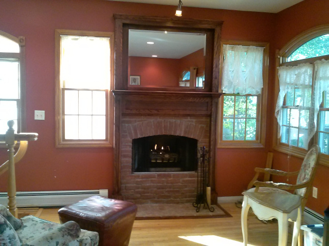 Woodburning fireplace with hidden personality...custom hanging screens, custom old brick arched firebox surround with hearth extention, beveled mirrored oak overmantel, mantel with hearth moulding all in hand rubbed red mahogany finish.