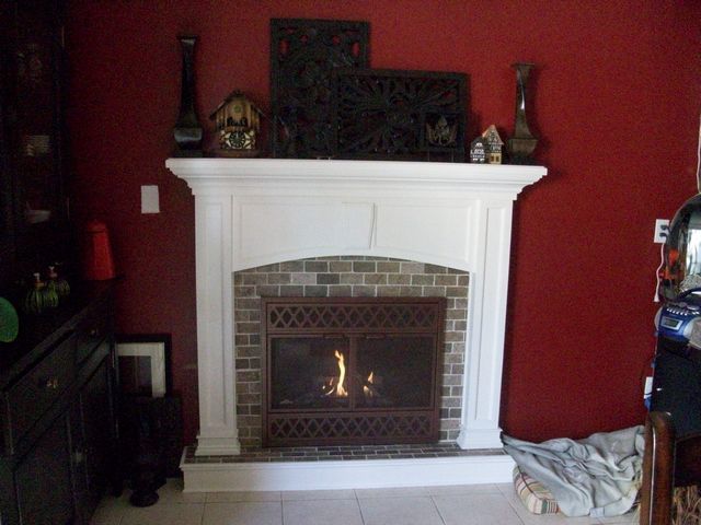 New brick tile surround, hearth step, custom mantel and custom door.